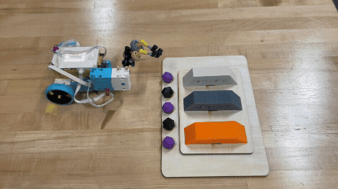 A robot made of LEGOs is placing an icosahedron on a 3D printed platform